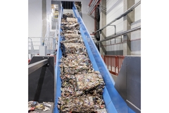 plastic waste going up a conveyor belt for recycling